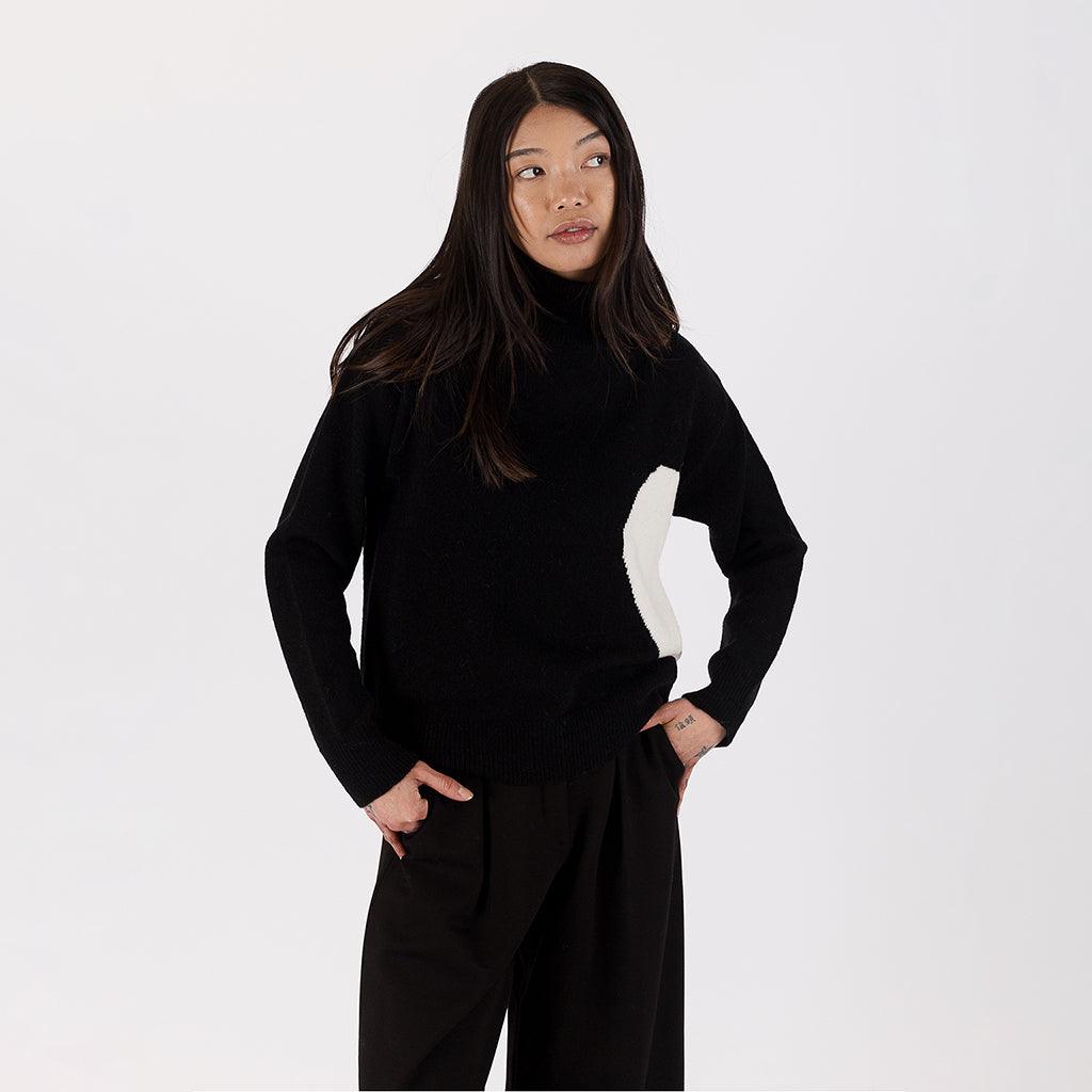 The heart detailing adds a unique and playful touch, making this sweater stand out as a statement piece. With its timeless design and cozy feel, this mock neck sweater is an essential addition to your collection, perfect for both casual and dressier occasions. 