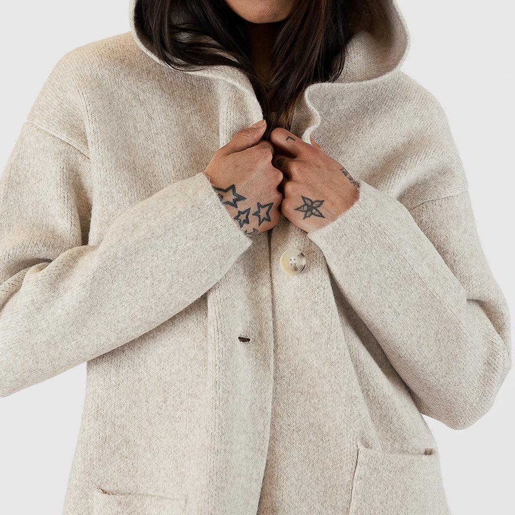  Its longer length provides extra coverage, making it perfect for keeping warm during the cooler months. The attached hood adds an extra layer of protection against the elements, while the timeless design ensures that this coat can be worn for years to come.