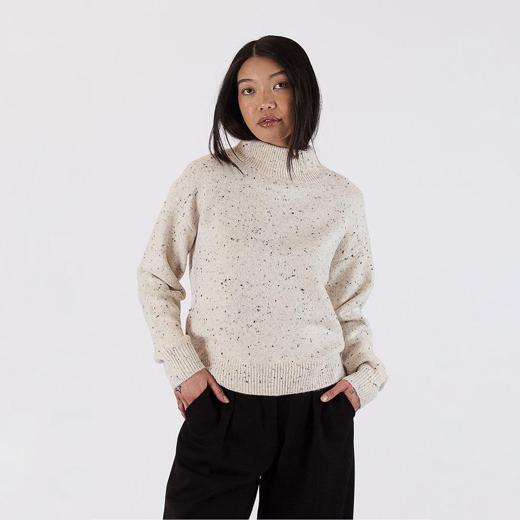 With its classic ribbing and relaxed fit, this sweater offers both comfort and style. The oat fleck color adds a touch of texture and depth to the classic design, making it a versatile piece that can be easily dressed up or down.