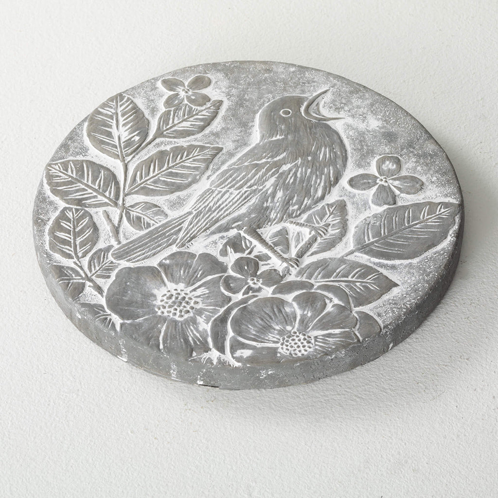 Add a touch of nature to your outdoor space with this beautiful singing bird stepping stone. The round cement accent has a carved gray finish that resembles real stone, with embossed flowers, leaves, and a feathered friend at the center. 